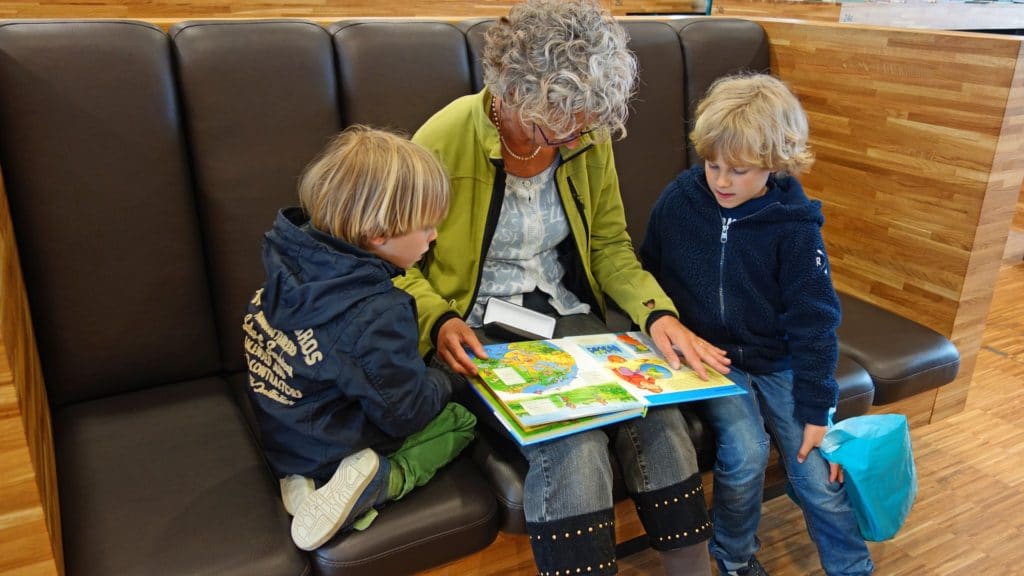 Frau liest mit Kindern ein Buch