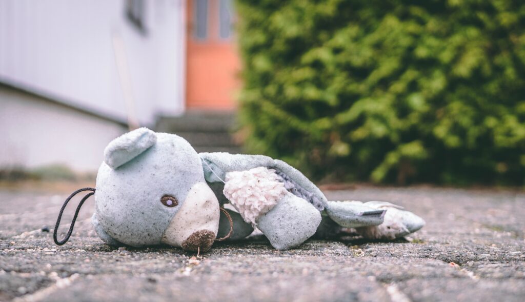 Gewalt in Kindertagesstätten. Ein beschädigter Teddybär liegt auf dem Boden