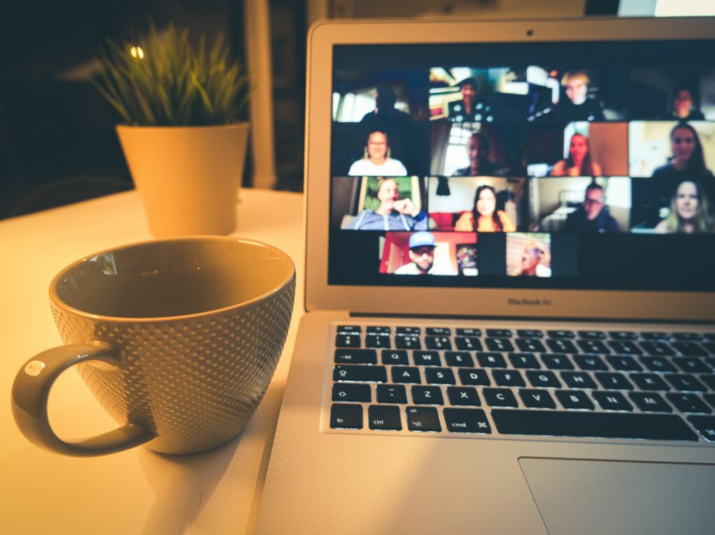 Ein Laptop mit einer Übersicht verschiedener Teilnehmer:innen an einem Online-Meeting.