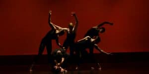 Gruppe von Tänzer:innen, die auf der Bühne performen