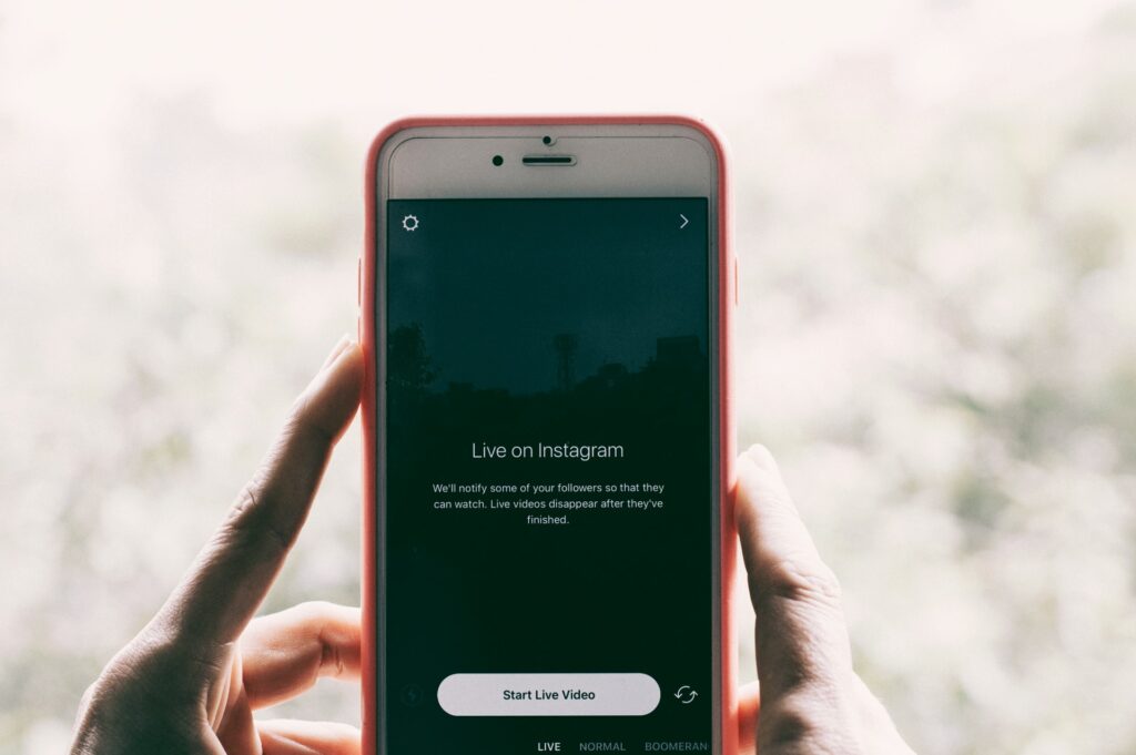 Smartphone mit geöffneter Instagram-App: auf dem Bildschirm steht "Live on Instagram"