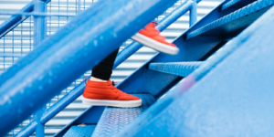 eine Person in orangen Turnschuhen läuft eine Treppe hoch