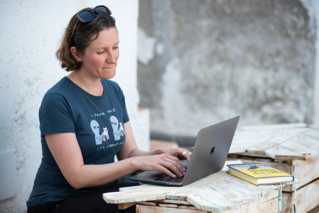 Frau in blauem T-Shirt mit Macbook