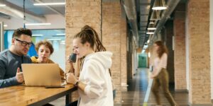 Junge Menschen stehen in modernem Büro. Verlagspraktikum