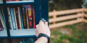 Person öffnet Bücherschrank. Open Access Erziehungswissenschaften