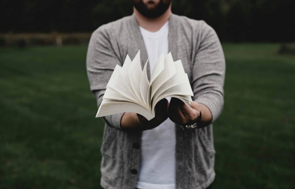 Mann blättert in Buch. Veröffentlichen in der Sozialen Arbeit