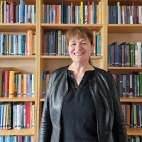 Barbara Budrich in front of book shelves